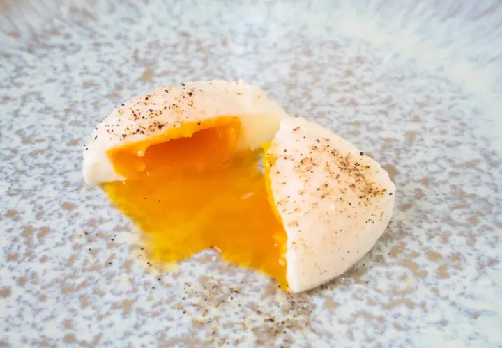 Perfekt pochiertes Ei mit flüssigem Eigelb, bestreut mit Pfeffer. Ein einfaches pochierte eier rezept für jeden Tag.
