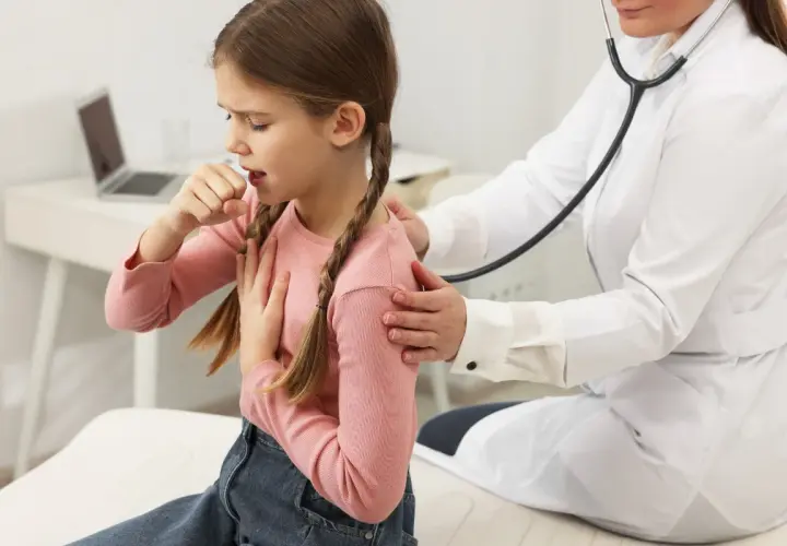 Bambina con tosse notturna, tossisce mentre il medico la ascolta con lo stetoscopio.
