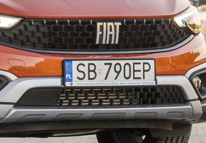 Pomarańczowy Fiat z tablicą rejestracyjną SB 790EP.