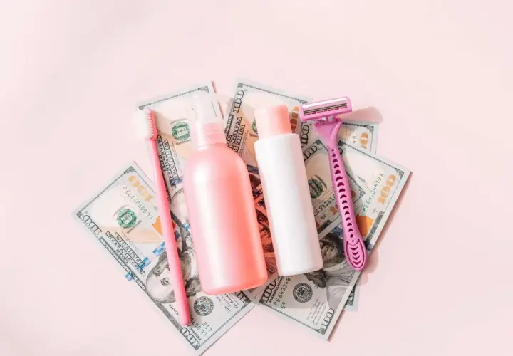 Rosa Rasierer, Zahnbürste und Kosmetikflaschen auf 100-Dollar-Scheinen. Ein Symbol für den "Pink Tax", der Frauen mehr kostet.