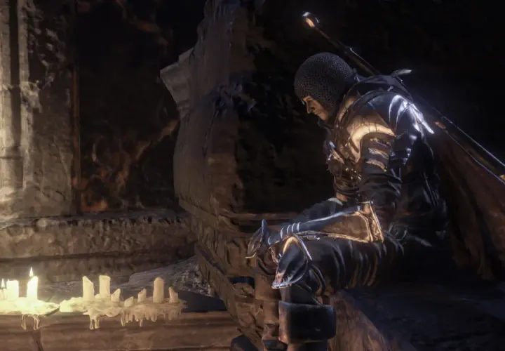 Rycerz w zbroi siedzi przy świecach, szukając wskazówek w mrocznym świecie. To może być kluczowy moment w twoim **dark souls poradnik**.