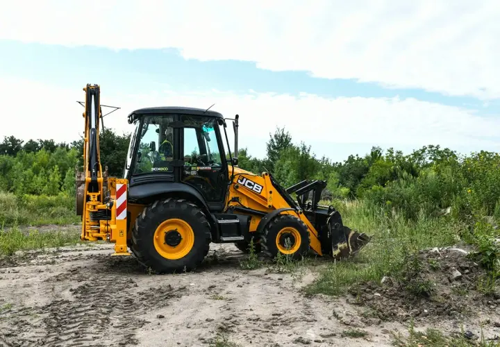 Żółta koparko-ładowarka JCB na placu budowy. Zastanawiasz się, ile kosztuje kurs na koparko-ładowarkę?