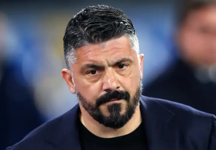 Gennaro Gattuso, zamyślony trener w granatowej marynarce, z charakterystyczną brodą i siwiejącymi włosami.