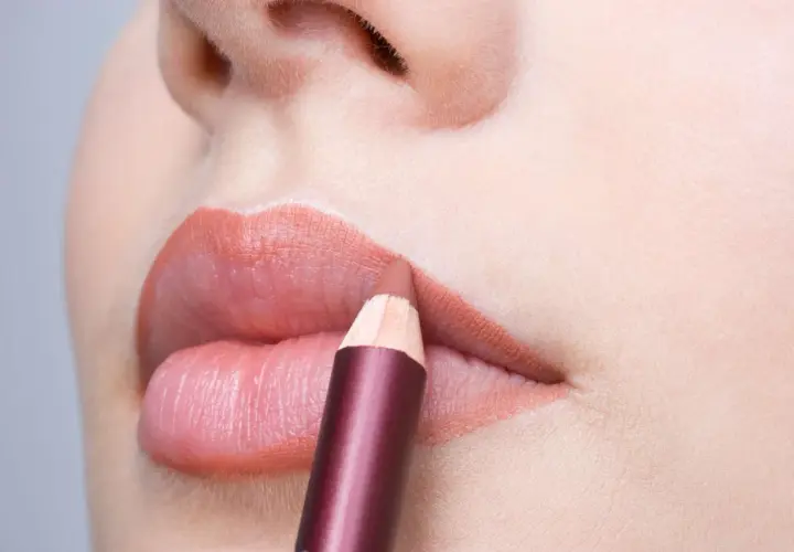 Close-up of lips with a lip liner pencil being applied.