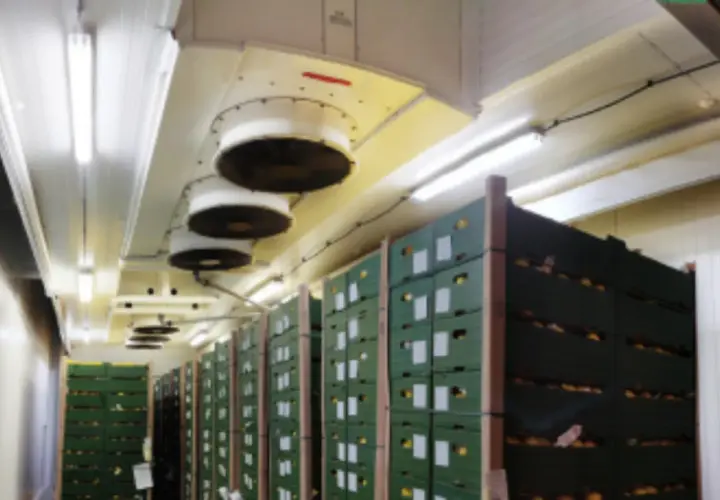 Almacén con cajas apiladas y ventiladores en el techo para el sistema de refrigerante CO2.