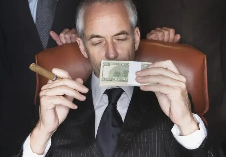 Mężczyzna w garniturze z cygarem w dłoni wącha stos banknotów. Sekret jak że 100 tys zrobić milion?