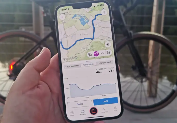 Mapa z trasą rowerową na telefonie, pokazująca drogi leśne dopuszczone do ruchu. Widok profilu wysokości i przycisk "Jedź".