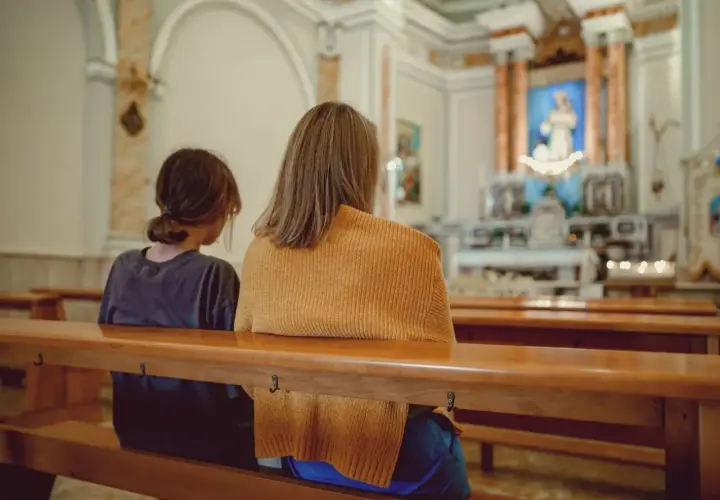 Dwie osoby siedzą w kościele, zastanawiając się, kto może zostać świadkiem bierzmowania.