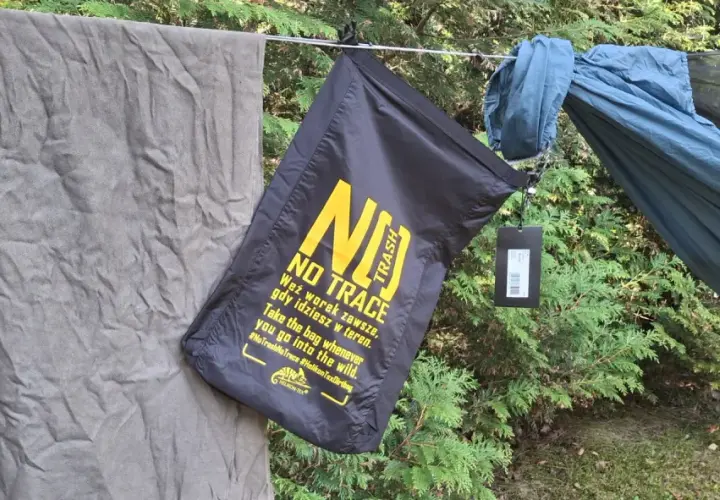 Czarny worek na śmieci z napisem "NO TRACE" przypomina o zasadach "leave no trace" podczas wypoczynku na łonie natury.