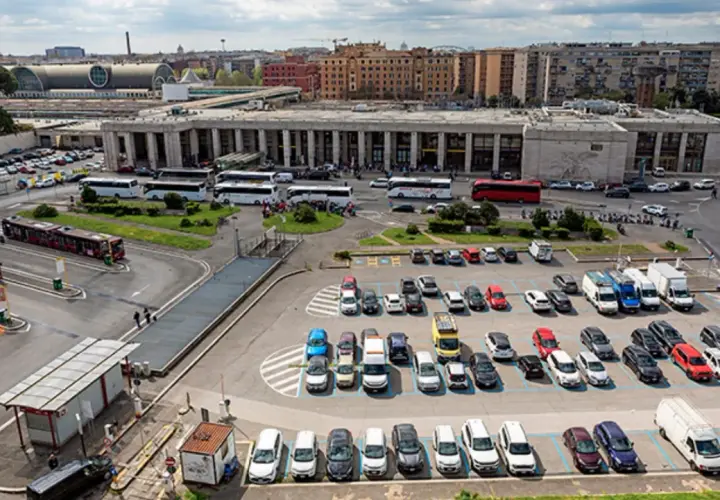 Ampio parcheggio di autobus e auto vicino alla stazione metro di Roma. Molti mezzi di trasporto pubblico e privato in un'area trafficata.
