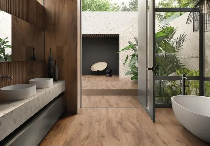 Bagno moderno con vasca freestanding, doppio lavabo e piante rigogliose. Un esempio di raffinate ristrutturazioni interne che uniscono natura e design.