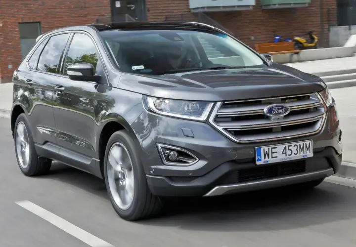 Szary Ford Edge w ruchu miejskim. Kierowca zadowolony, jak wskazują ford edge opinie.