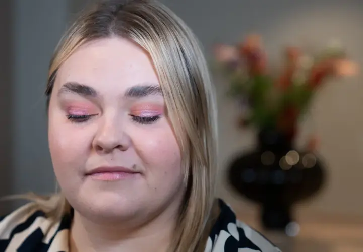 En närbild på en kvinna med rosa skimrande ögonskugga på sina hooded eyes.