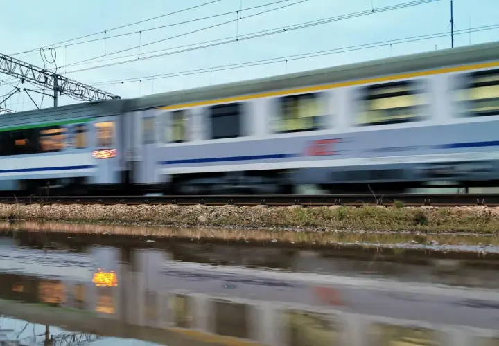 Pędzący pociąg Intercity, odbijający się w kałuży. Nauczyciel z legitymacją może liczyć na zniżki.