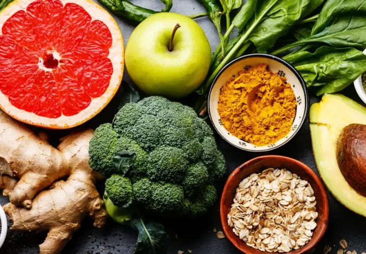 Bunte Auswahl an gesunden Lebensmitteln: Grapefruit, Apfel, Brokkoli, Ingwer, Spinat, Avocado, Haferflocken und Gewürze. Eine Vielfalt an jodhaltigen Lebensmitteln für eine ausgewogene Ernährung.
