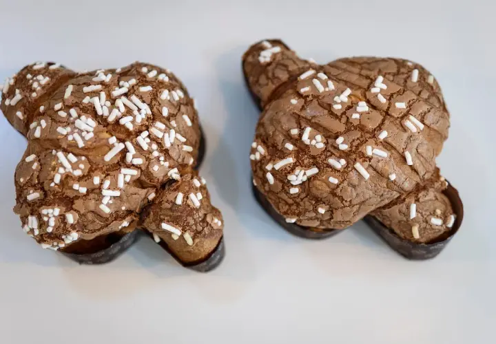 Dos deliciosas colomba de chocolate, cubiertas de azúcar perlado, listas para ser disfrutadas.