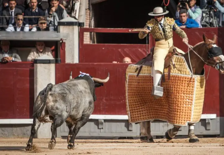 Joaquín Moreno Silva, un torero a caballo, se enfrenta a un toro en la arena.