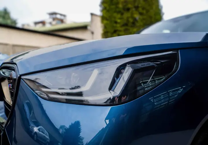 Błyszczący, niebieski lakier BMW z nowoczesnym reflektorem LED. Detailing podkreśla jego sportowy charakter.