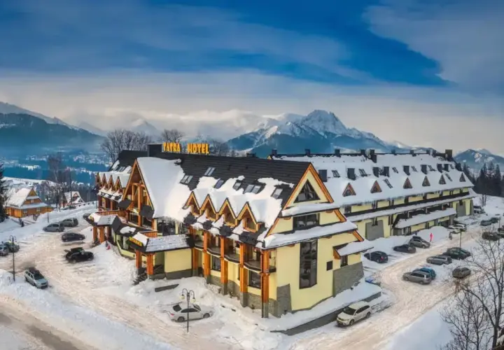Zimowy krajobraz z hotelem w stylu góralskim. W tle majestatyczne Tatry. Idealne miejsce na wypoczynek, cyrhla zakopane.