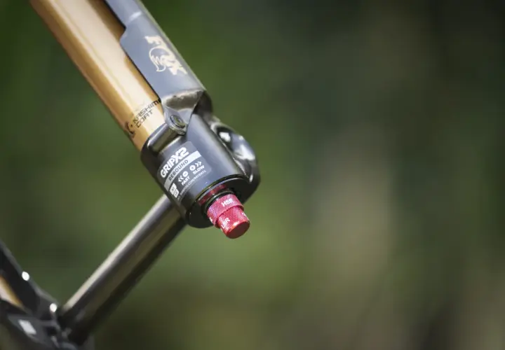 Close-up of a gold and black Fox 36 FIT4 fork with Kashima Coat, featuring the GRIP2 damper and a red adjustment knob.
