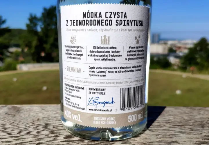 Etykieta butelki wódki czystej opisuje różnicę między wódką czystą zbożową a ziemniaczaną w smaku i aromacie, podkreślając ziemniaczaną jako aksamitną z nutą ziemniaka.