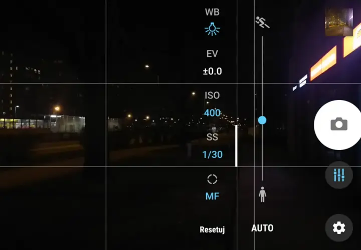 Ekran telefonu z widokiem nocnym. Ustawienia aparatu pokazują, jak ustawić długi czas naświetlania. Widoczny tryb manualny (M) i czas 1/30s.