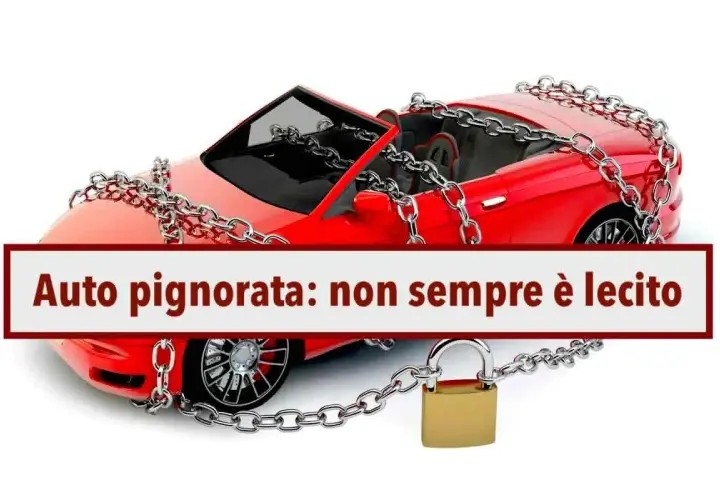 Auto rossa con catene e lucchetto, simbolo di pignoramento auto con finanziamento in corso.