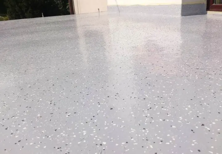 Nowoczesny kamienny dywan koszt 1m2. Jasnoszara posadzka z drobnymi, kolorowymi płatkami, idealna na taras lub balkon.