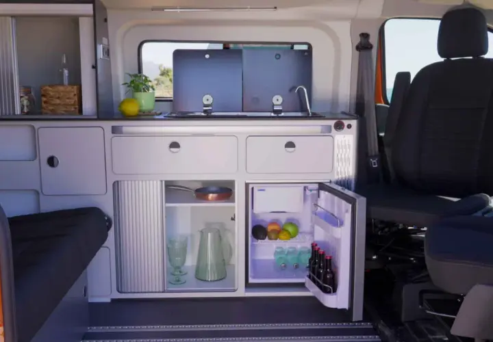 Aménagement astucieux de la soute d'un camping-car : cuisine fonctionnelle, réfrigérateur et rangements optimisés pour un voyage serein.