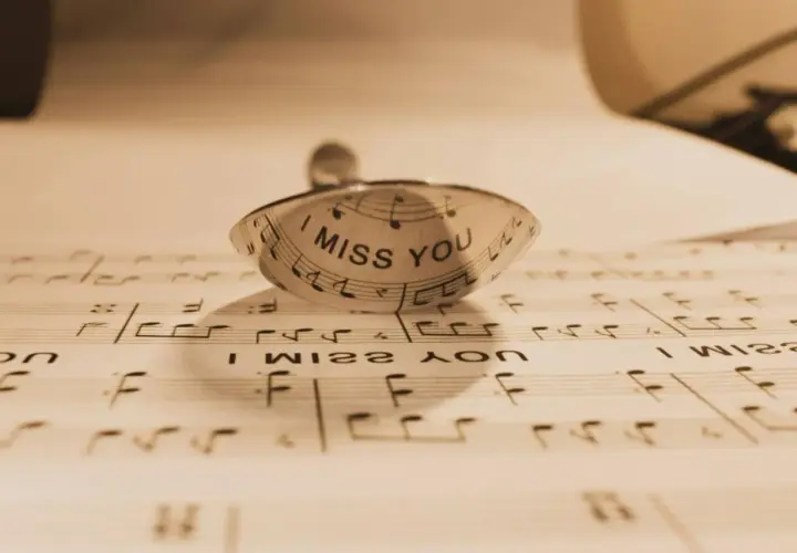 Un anillo con la frase "I MISS YOU" sobre partituras. Un detalle que evoca indirectas y frases de te echo de menos.