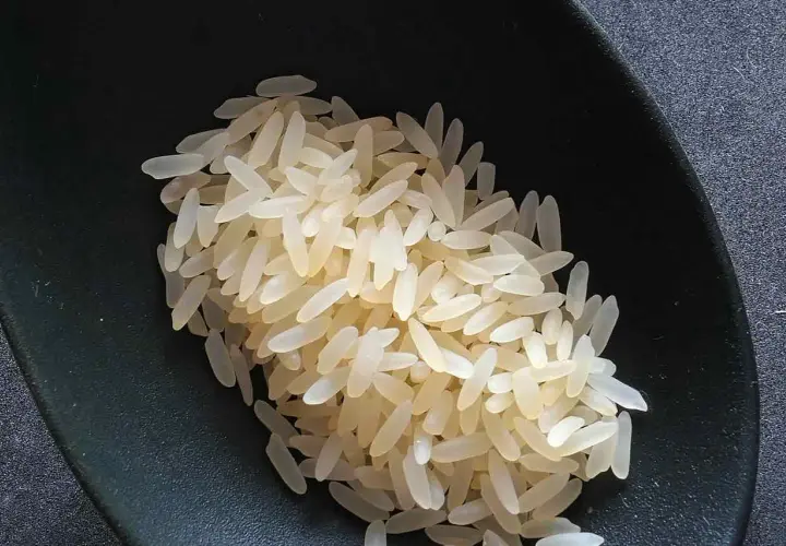Chicchi di riso originario pronti per la cottura, in una ciotola scura.
