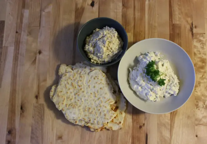 Två skålar med krämig tarator djej, en med persilja, bredvid tunna, krispiga bröd.