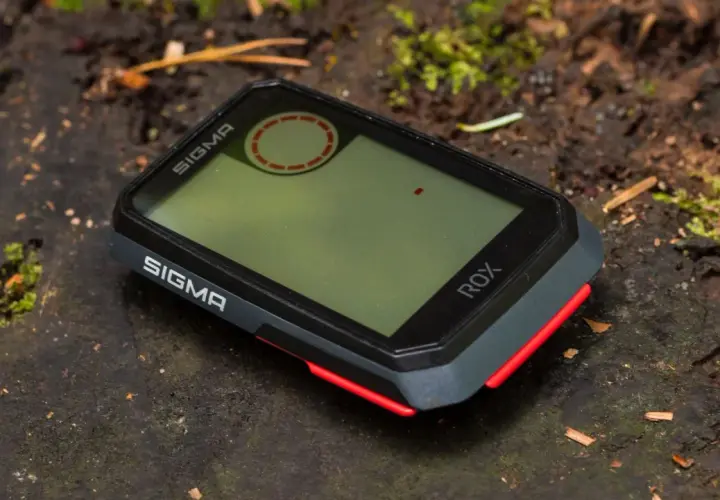 Sigma ROX GPS na leśnym pniu. Ten zaawansowany licznik rowerowy jest gotowy na każdą przygodę.