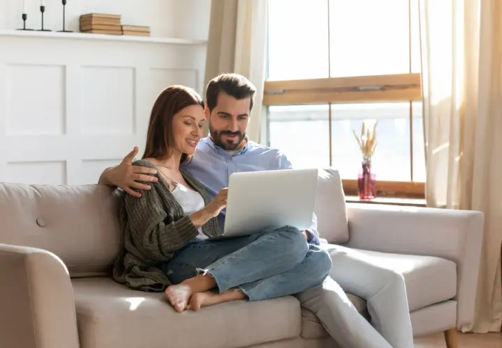 Couple planifiant l'amélioration de leur habitat, consultant un prêt sur leur ordinateur.