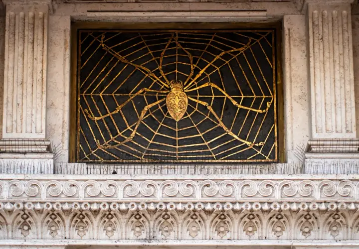 Ragno dorato su ragnatela nera, dettaglio architettonico del quartiere Coppedè interni.