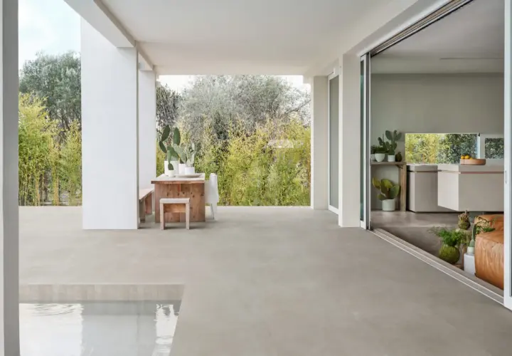 Terrazza con piscina e cucina moderna, pavimentata in gres materiale che si estende all'esterno.