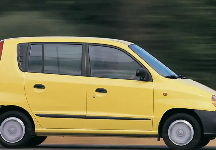 Żółty Hyundai Atos w ruchu, z rozmytym tłem sugerującym prędkość.