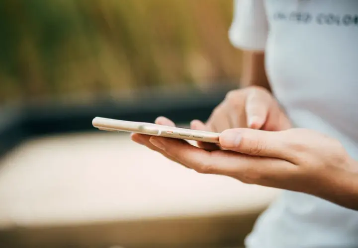 Mani che scorrono su uno smartphone dorato. Come in un ciclo, chi fa orbiting ritorna sempre a connettersi.