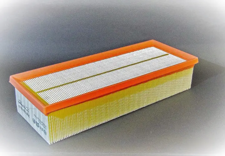 Filtro de aire rectangular con marco naranja y pliegues amarillos. Pregúntate cada cuanto se cambia filtro de aire para mantener tu motor limpio.