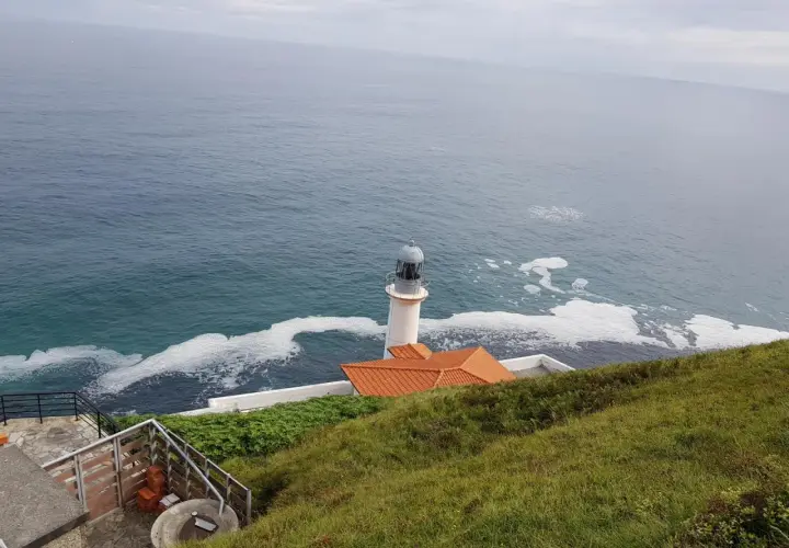 El faro del pescador en Santoña se alza vigilante sobre el mar Cantábrico, con espuma blanca adornando las olas.