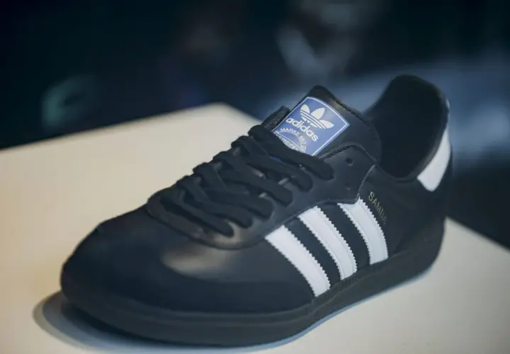 Schwarzer Adidas Samba Schuh mit weißen Streifen und goldener "SAMBA"-Prägung. Ein Klassiker, der seinen Preis wert ist – einer der teuersten Adidas Schuhe.