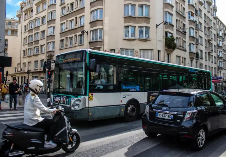 Paryż: autobus miejski i skuter na ulicy, symbolizujące dojazd do centrum z lotniska Charles de Gaulle.