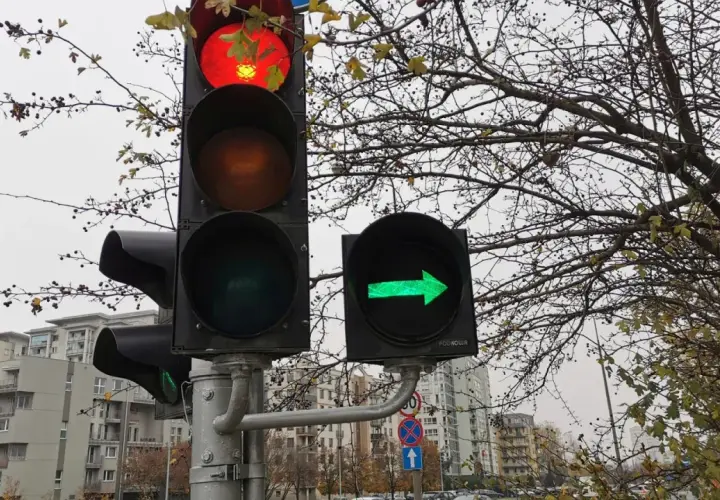 Sygnalizacja świetlna: czerwone światło na głównym sygnalizatorze i zielona strzałka w prawo na dodatkowym.
