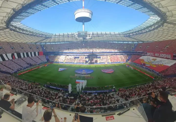 Stadion wypełniony kibicami na meczu Górnik Zabrze – Raków Częstochowa. Ogromna flaga z orłem i napisami na trybunach.