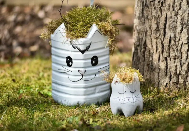 Urocze dekoracje ogrodu DIY w kształcie kotków, wykonane z recyklingu, dodają uroku zielonej trawie.