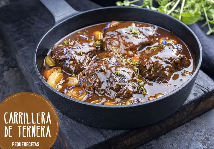 Carrilleras de ternera estofadas en salsa oscura, con trozos de verdura y hierbas. ¡Un clásico de la receta de la abuela!