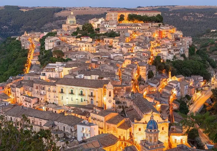 Illuminated Ragusa, Sicily, glows at dusk. Explore its Baroque architecture and charming streets for unforgettable things to do in Ragusa.