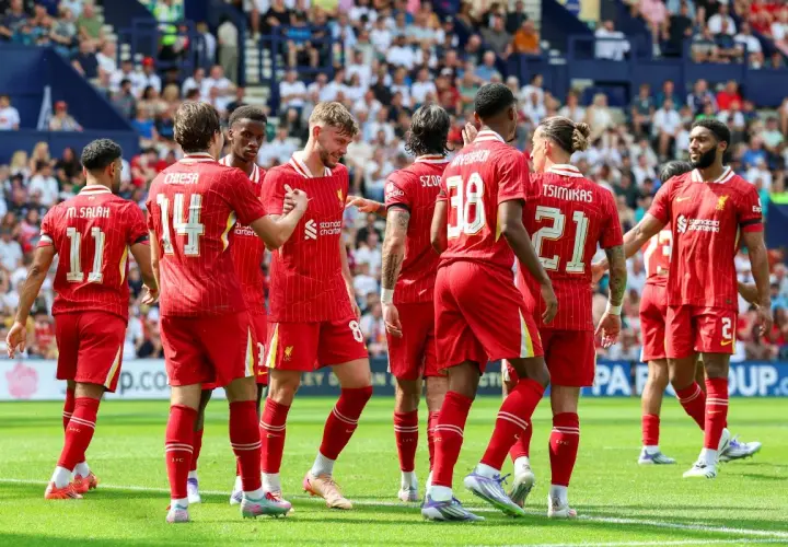 Piłkarze Liverpoolu, mistrzowie Anglii, świętują na boisku. Widać numery 11, 14, 8, 38, 21 i 2.