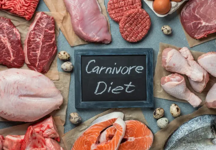 Różnorodne mięsa, ryby i jaja na stole. Tabliczka z napisem "Carnivore Diet" sugeruje, że to inspiracja dla osób szukających efektów diety karniwora.