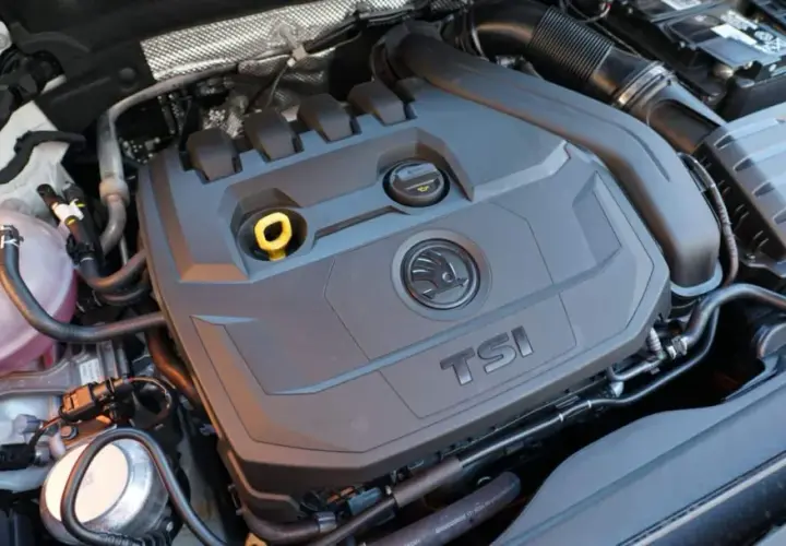 Motor 1.5 TSI 150cv, con su tapa negra y logo Skoda. Se aprecian manguitos y depósito de refrigerante.
